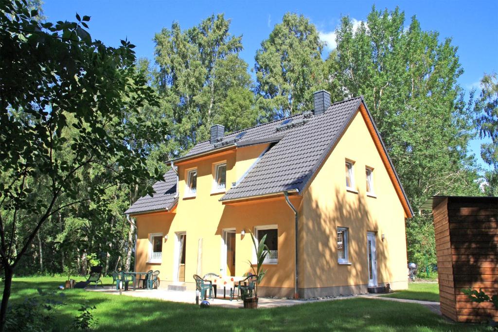 オストゼーバート・カールスハーゲンにあるFerienwohnungen Karlshagen USE 3010の庭の黒屋根黄色い家