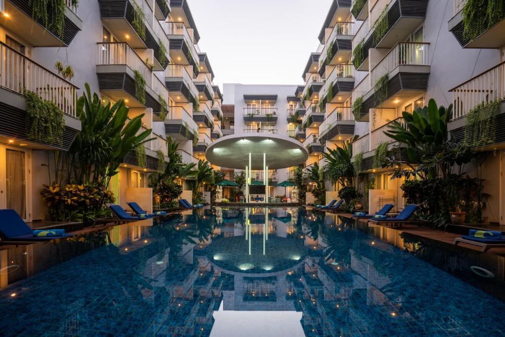 a swimming pool in the middle of a building at EDEN Hotel Kuta Bali in Kuta