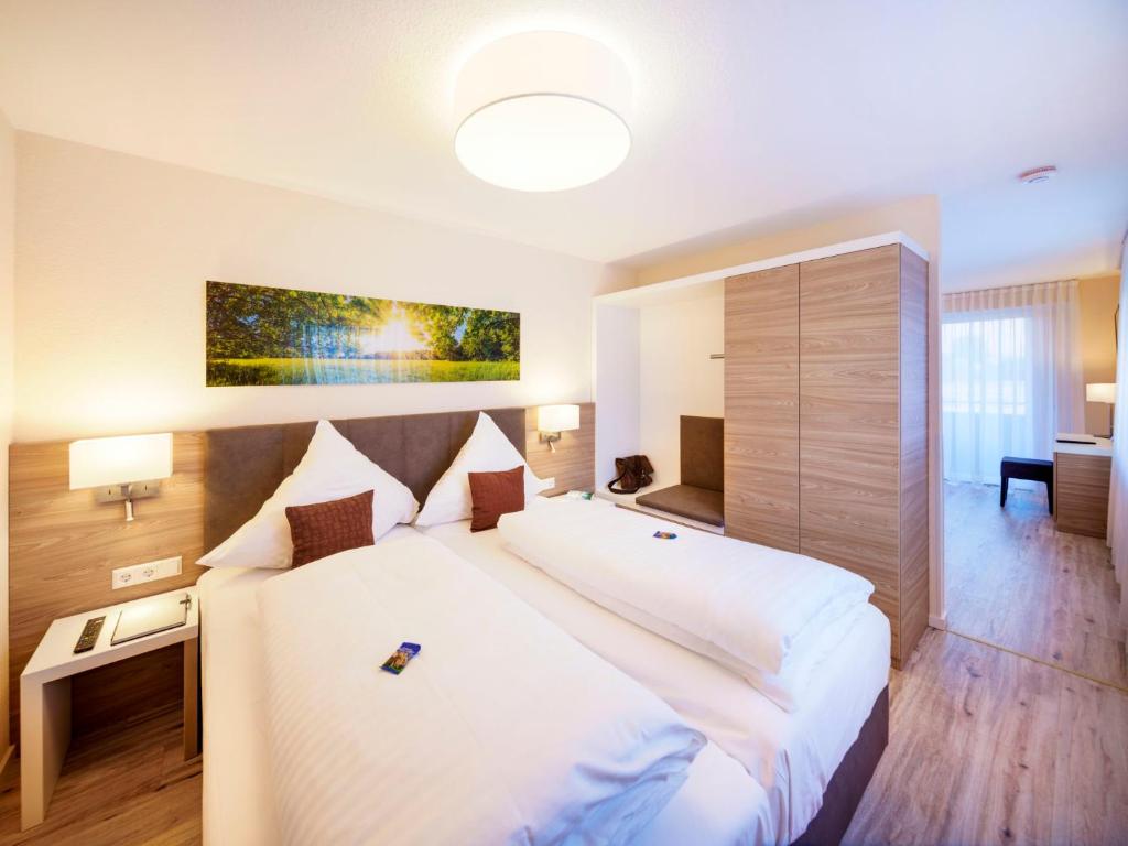 ein Schlafzimmer mit einem großen weißen Bett in einem Zimmer in der Unterkunft Hotel Berkheimer Hof in Esslingen