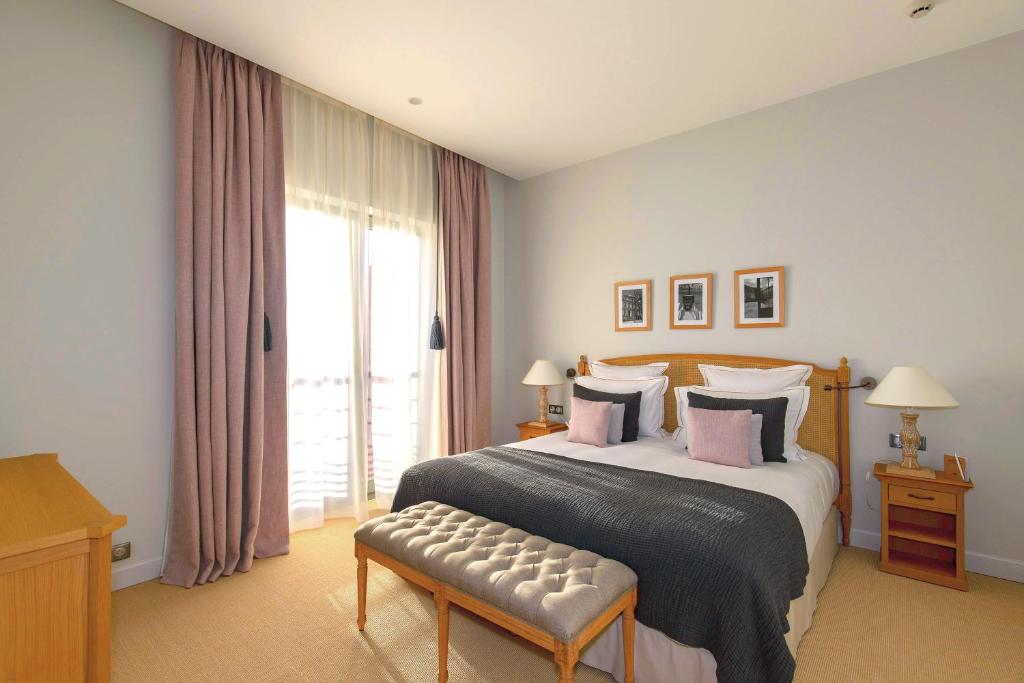 um quarto com uma cama e uma grande janela em Appartements Chais Monnet em Cognac