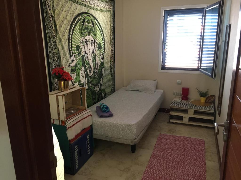 niewielka sypialnia z łóżkiem i oknem w obiekcie Papá Totë w mieście Playa Honda