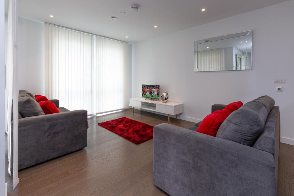 - deux canapés dans le salon avec des oreillers rouges dans l'établissement Luxury Central London Apartment, à Londres