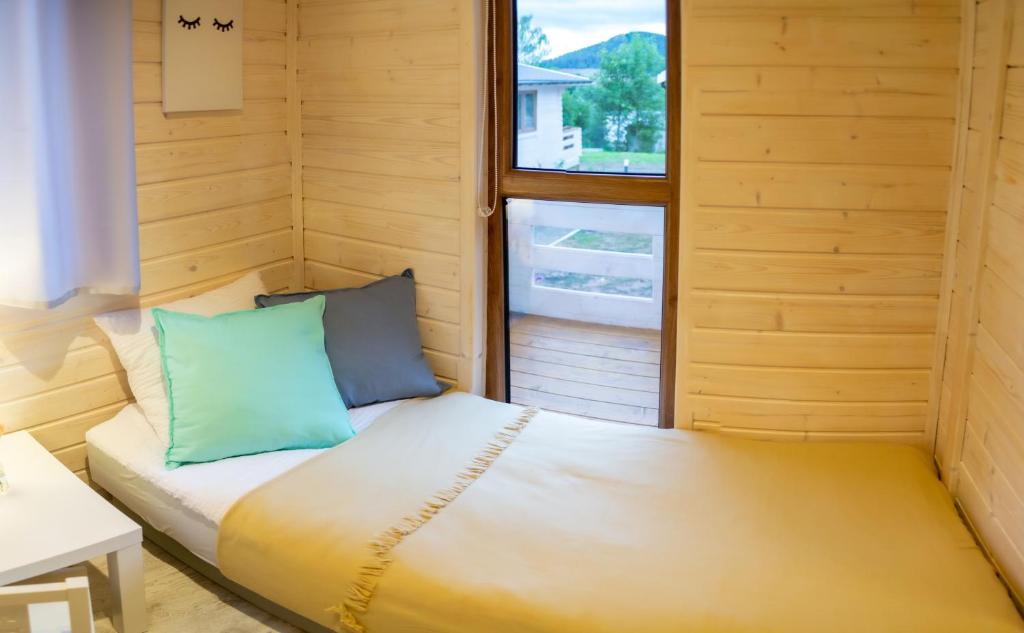 ein kleines Bett in einem Zimmer mit Fenster in der Unterkunft Sielankownia in Radków