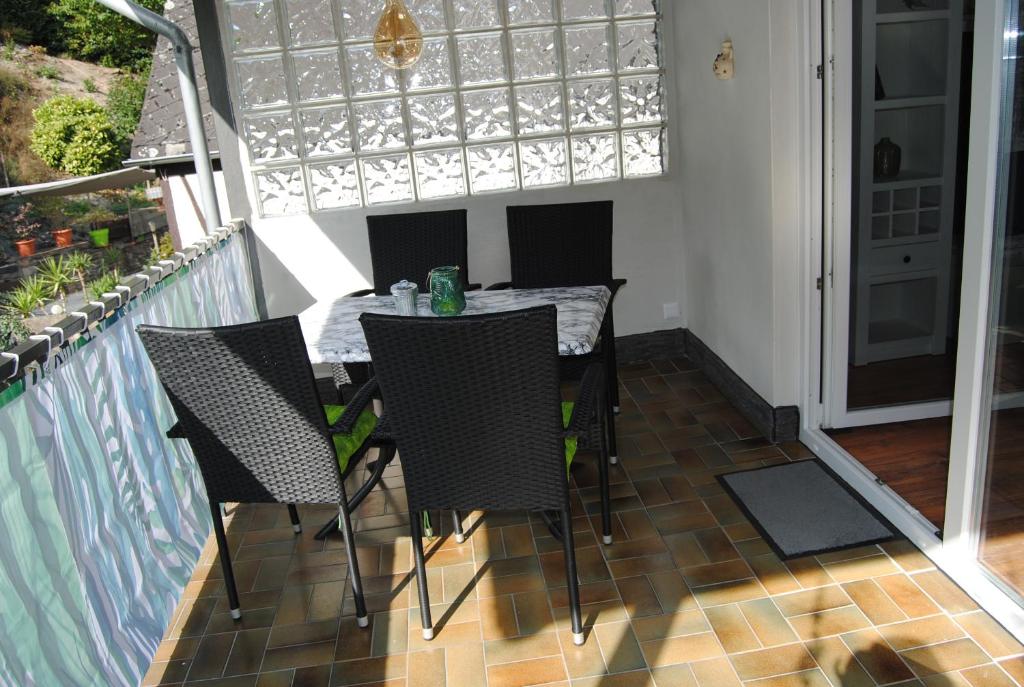 a patio with a table and chairs on a balcony at Ferienwohnung Bacharach-Steeger Tal in Bacharach