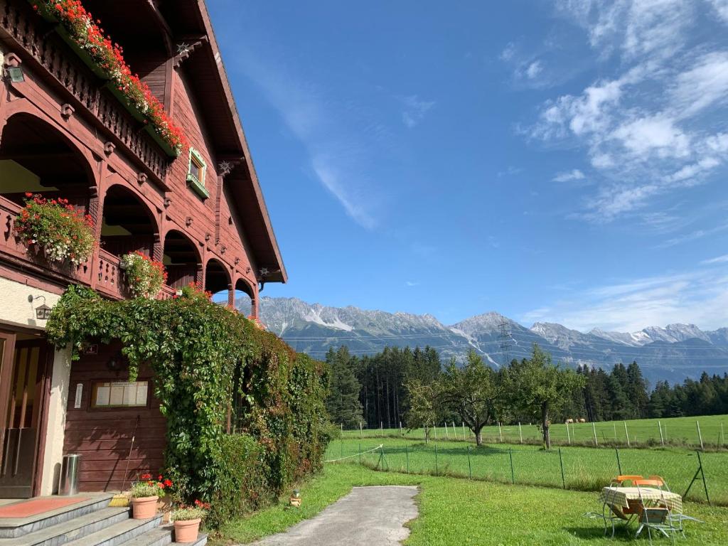 ein Gebäude mit Bergblick im Hintergrund in der Unterkunft Landhotel Gasthof Eichhof Natters in Innsbruck