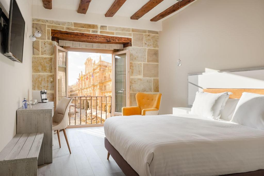 una camera da letto con un letto grande e un balcone di Salamanca Luxury Plaza a Salamanca