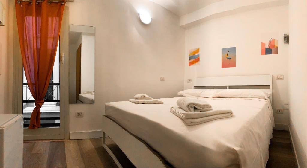Un dormitorio blanco con dos toallas en una cama. en Pied a Terre Barberini, en Roma