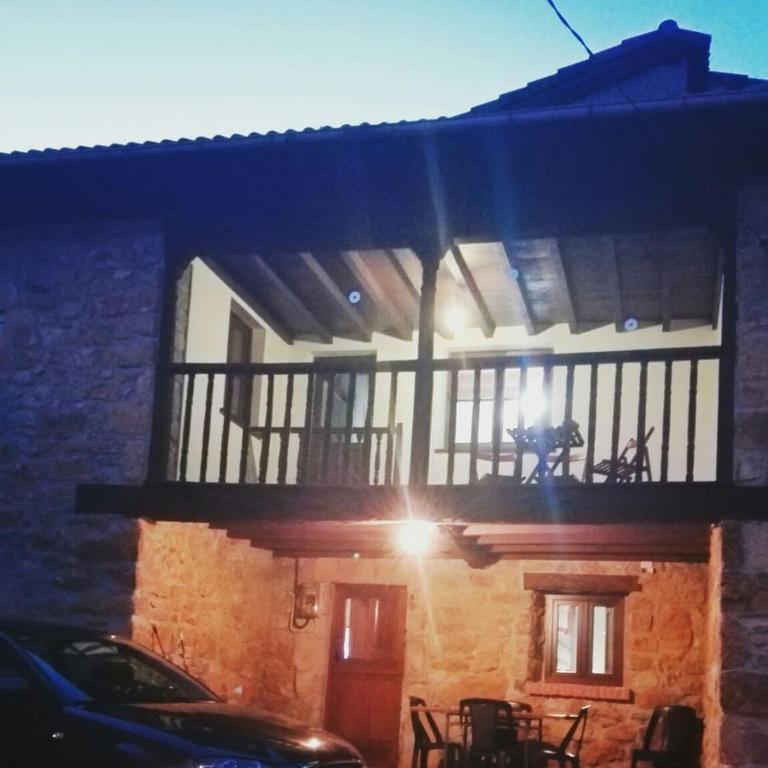a building with a balcony with a person on it at Casalacapillajelgueres in Cangas de Onís
