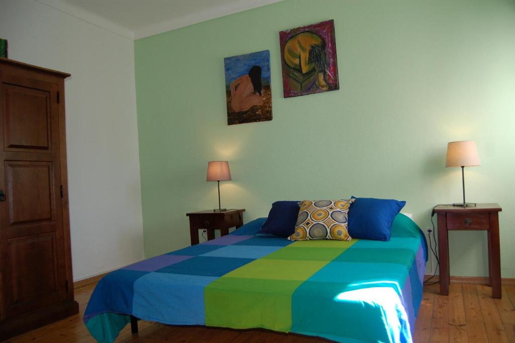 a bedroom with a bed with a colorful blanket at Casa das 4 estações in Castelo Branco