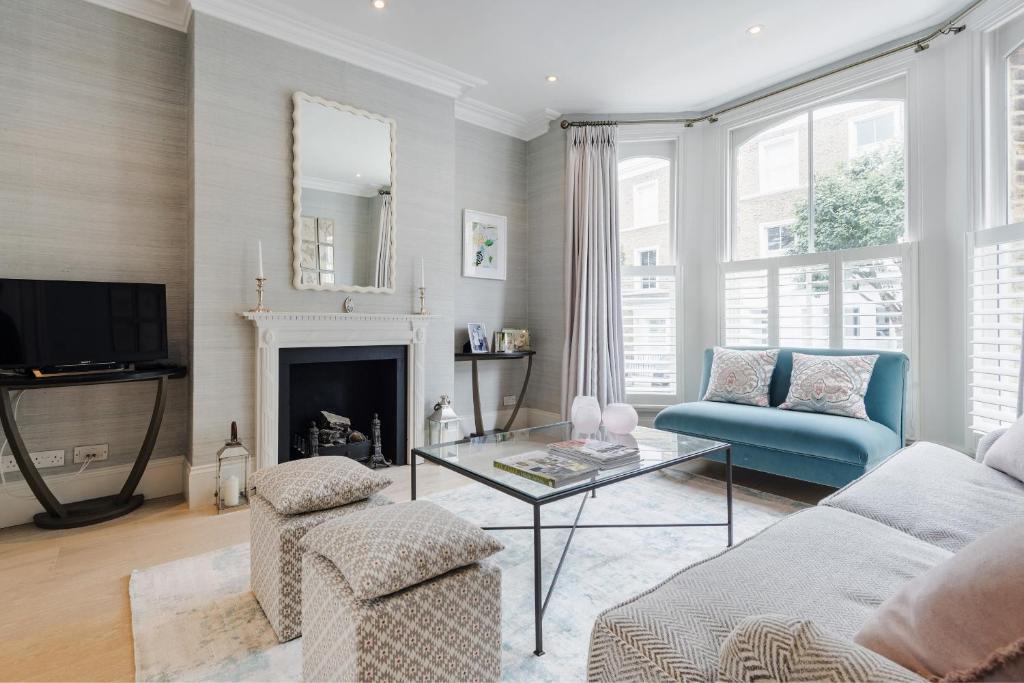 uma sala de estar com um sofá e uma mesa em Chic Wandsworth Home with Patio by UndertheDoormat em Londres