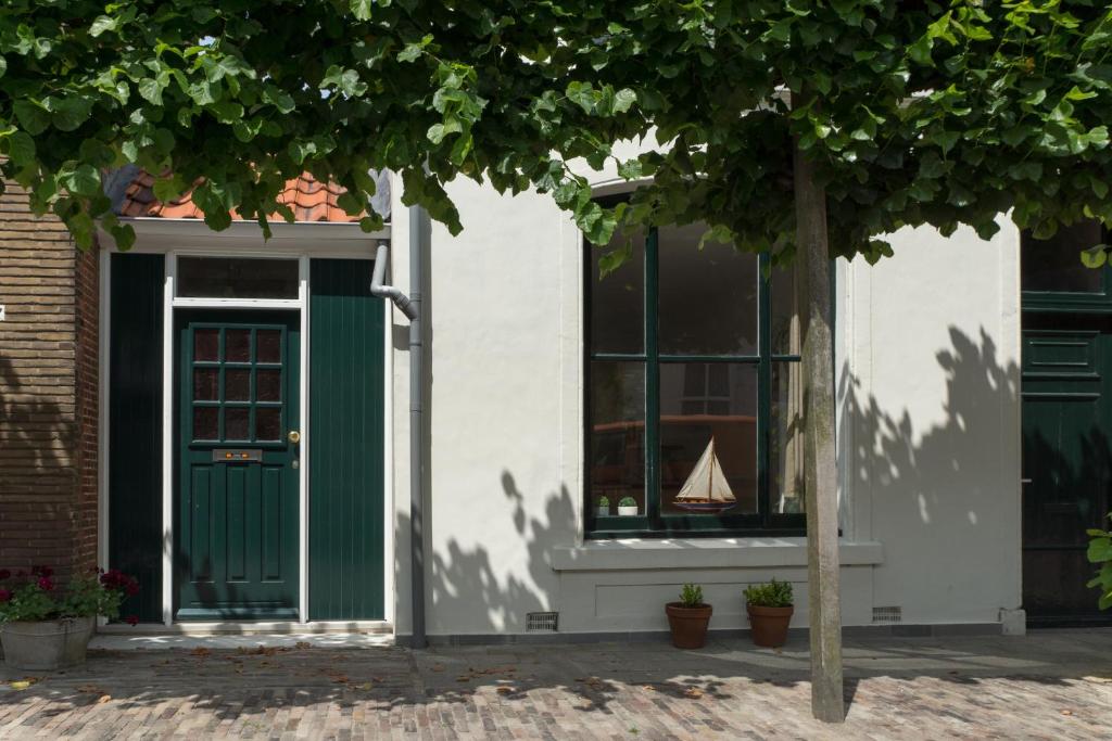 uma casa com uma porta verde e um barco na janela em De Babbelaar em Middelburg