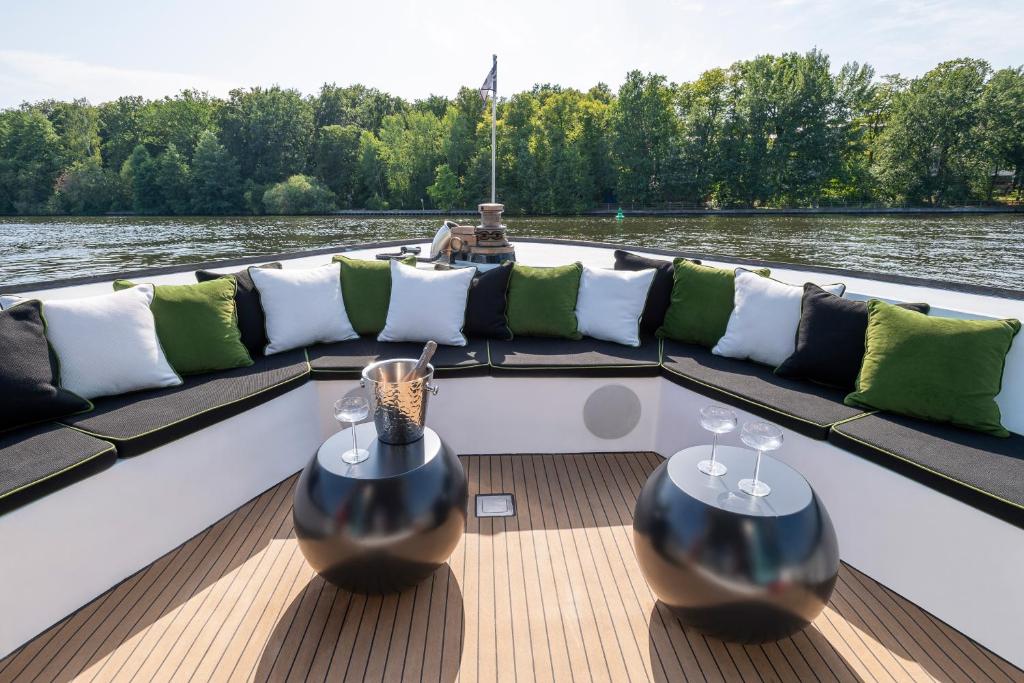 a boat with couches and wine glasses on the water at GRACE Suite mit zwei Schlafzimmern in Berlin
