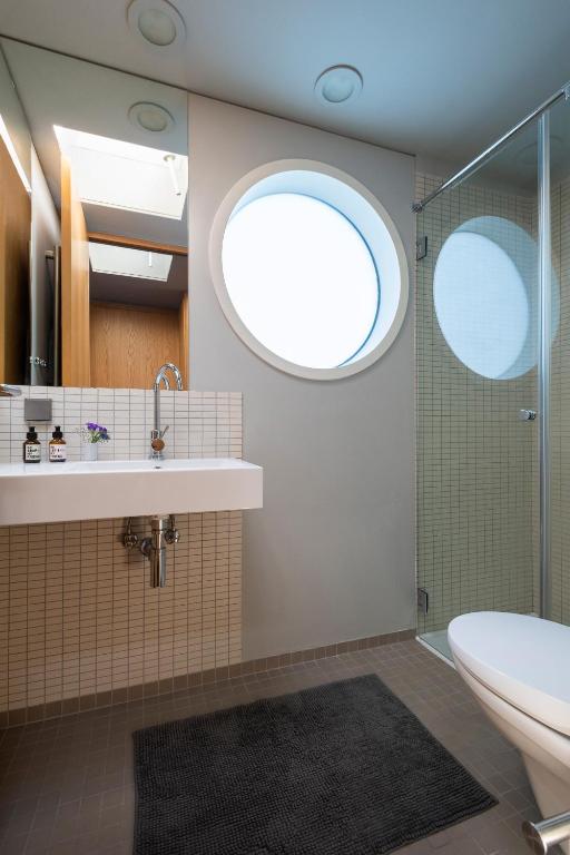 a bathroom with a sink and a shower with a window at GRACE Suite mit zwei Schlafzimmern in Berlin