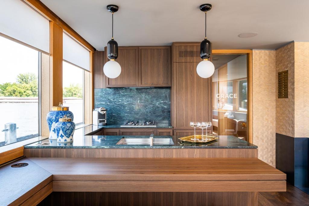 a kitchen with wooden cabinets and a counter top at GRACE Suite mit zwei Schlafzimmern in Berlin