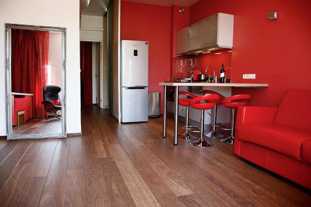 a kitchen with red walls and red chairs and a red couch at Prinsenhuis in Amsterdam