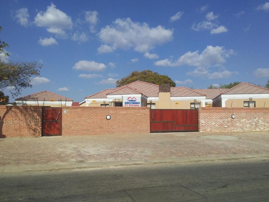 a row of houses with a red brick fence at Trianca guest house in Welkom