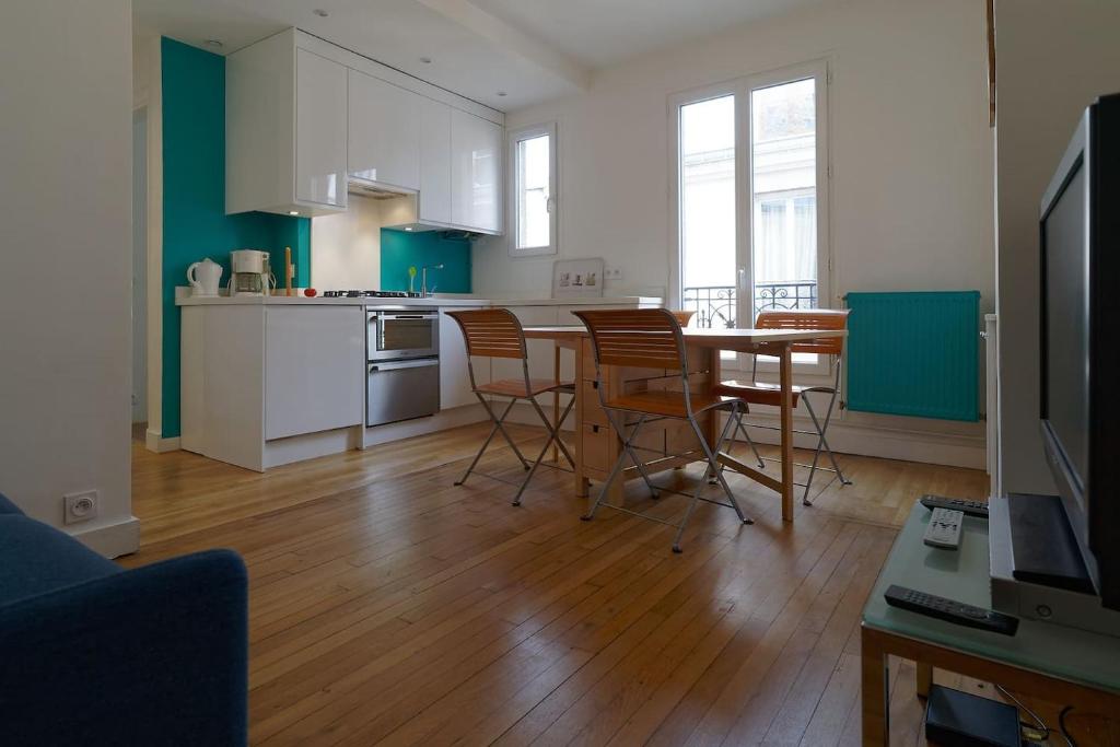 una cucina e una sala da pranzo con tavolo e sedie di Quiet apartment near Montmartre a Parigi