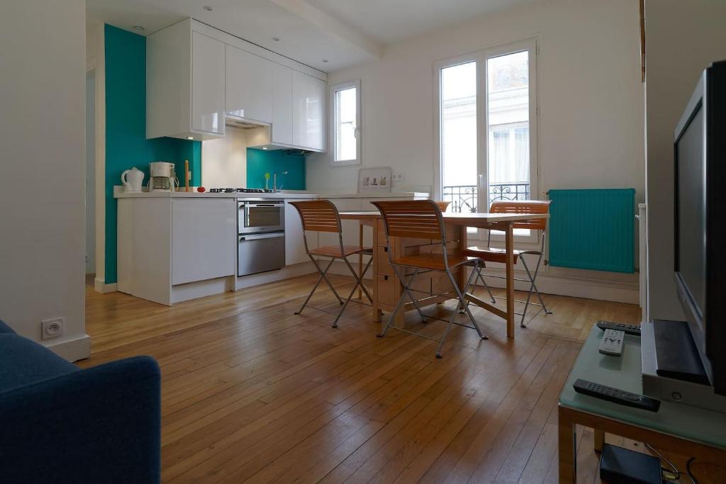 une cuisine et une salle à manger avec une table et des chaises dans l'établissement Quiet apartment near Montmartre, à Paris