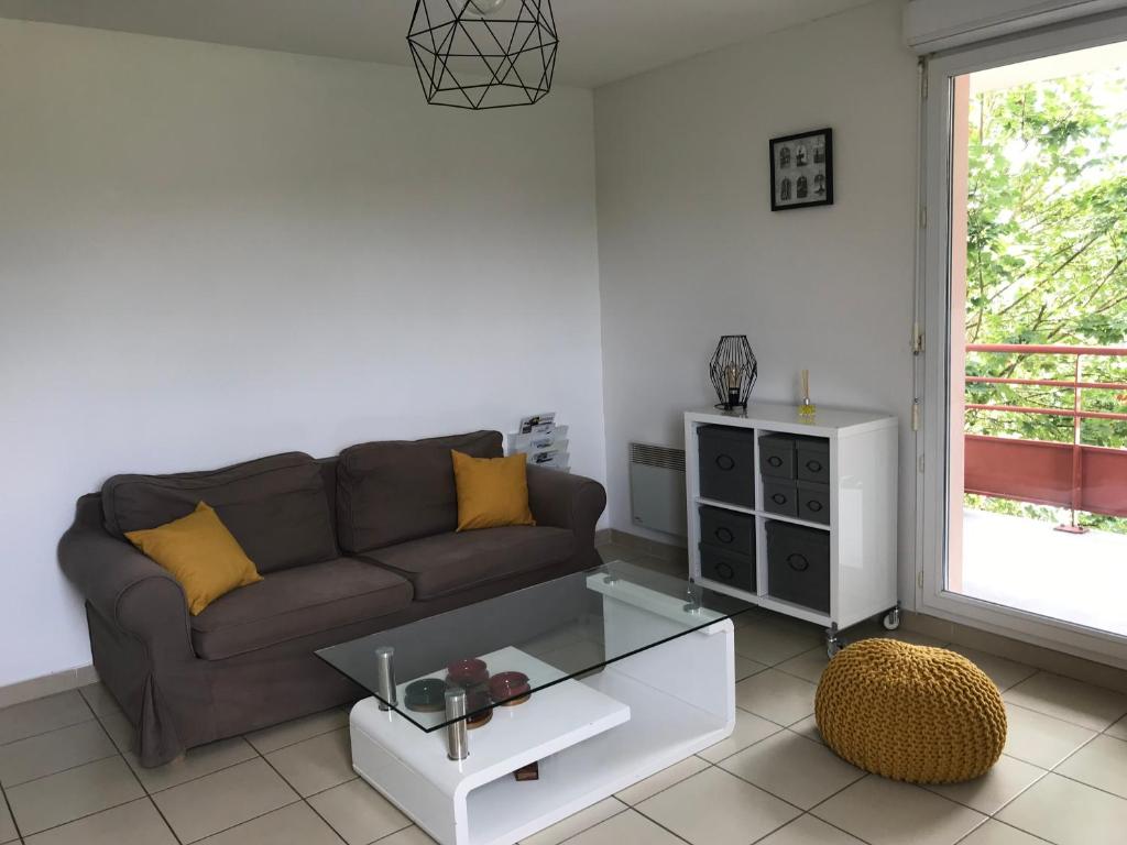 ein Wohnzimmer mit Sofa und Tisch in der Unterkunft Appartement au milieu des lacs, au bord du Guiers in Aoste