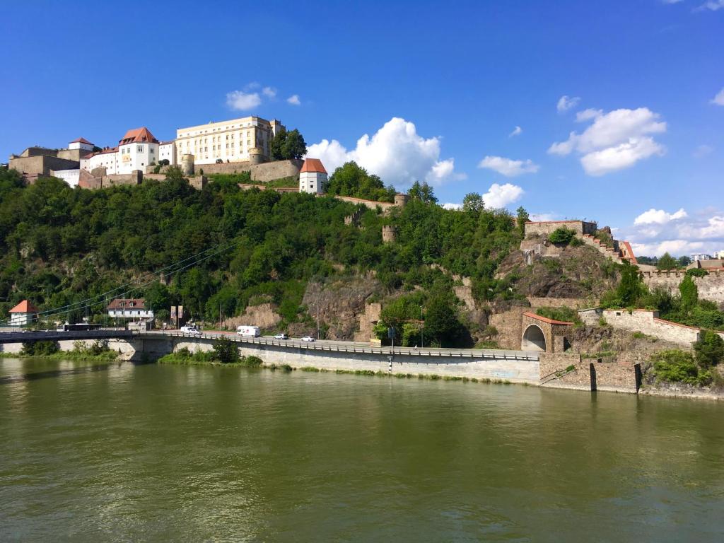 a bridge over a river with buildings on a hill at Morgentau Penthouse in Passau