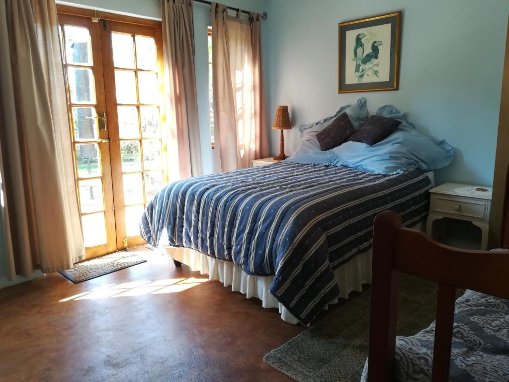 a bedroom with a bed with a blue comforter at Tucked away in the tree tops in Hillcrest