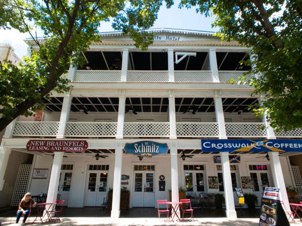 un edificio con sillas rojas delante de él en Schmitz Bed & Breakfast, en New Braunfels