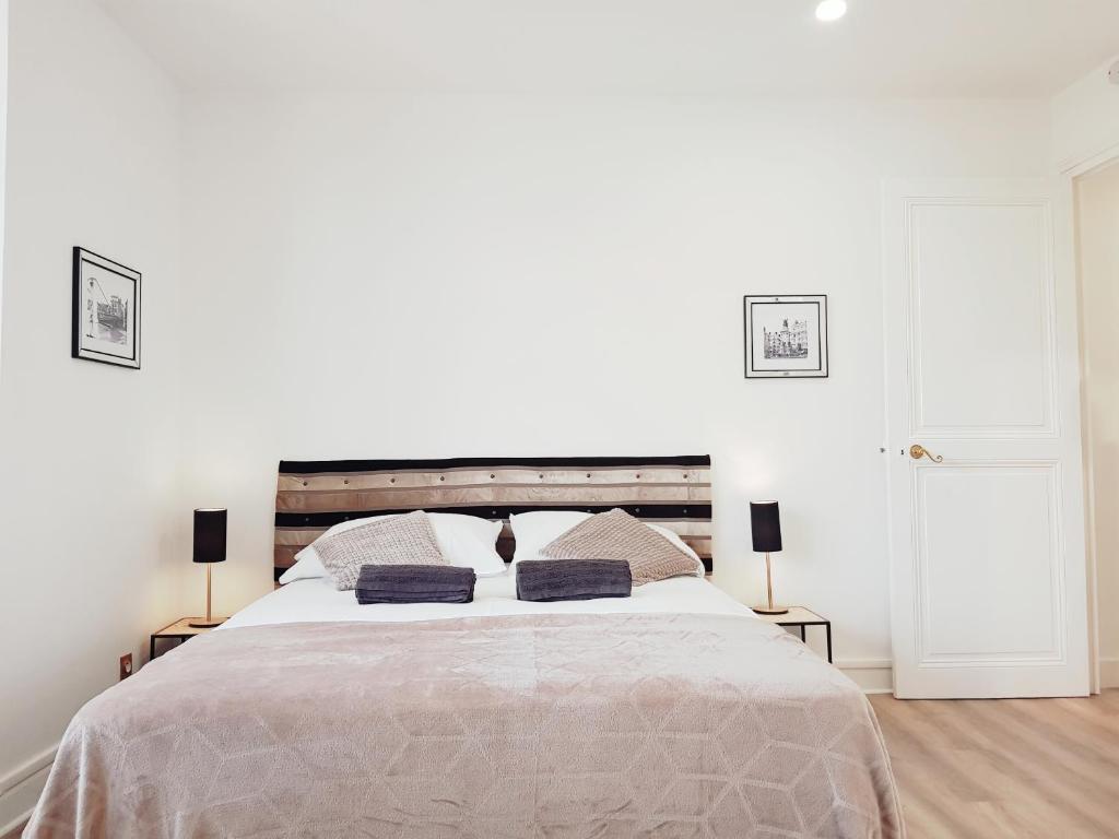 1 dormitorio blanco con 1 cama grande y 2 lámparas en François 1er au Manoir en Grenoble