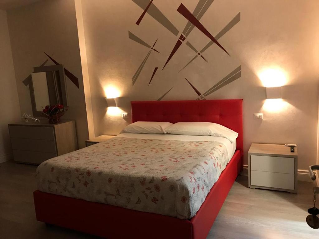 a bedroom with a red bed and a clock on the wall at Carpe Diem in Lamezia Terme