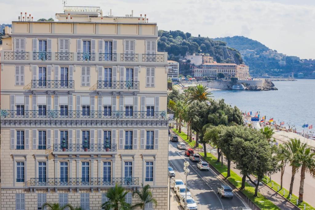 a building on a street next to the water at AU BEAU RIVAGE AP2049 by RIVIERA HOLIDAY HOMES in Nice