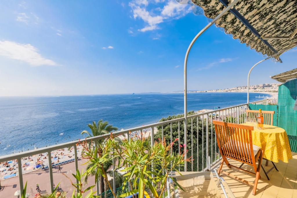 a balcony with a table and a view of the beach at AU BEAU RIVAGE AP2049 by RIVIERA HOLIDAY HOMES in Nice
