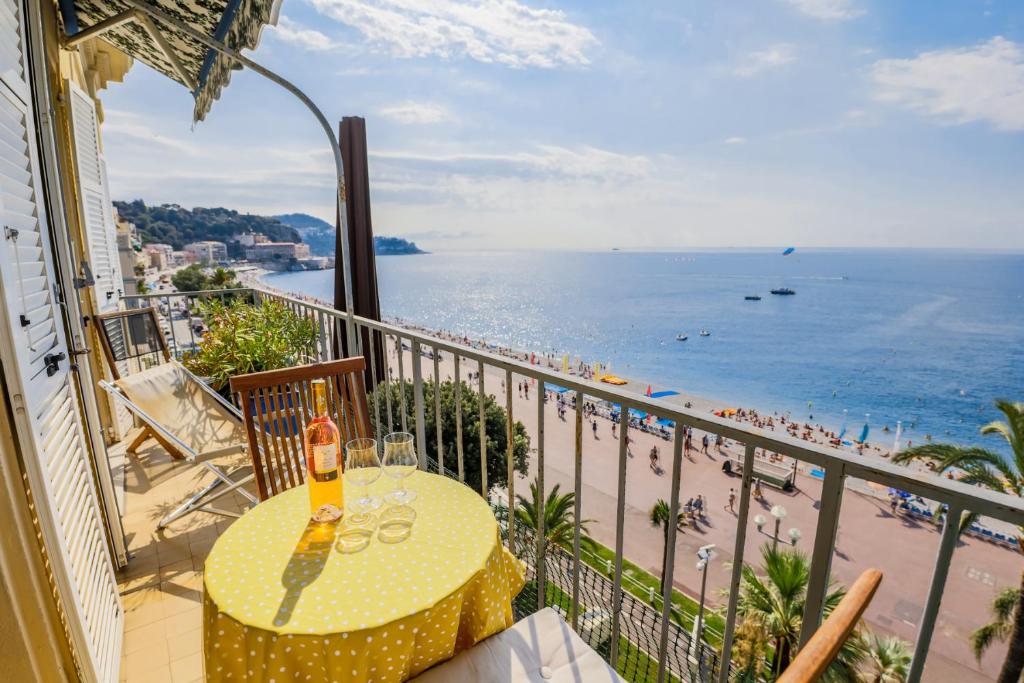 d'un balcon avec une table et une vue sur la plage. dans l'établissement AU BEAU RIVAGE AP2049 by RIVIERA HOLIDAY HOMES, à Nice