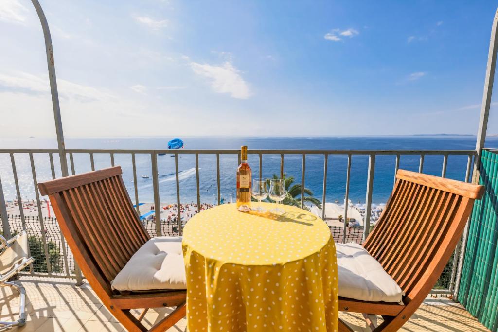 a table and chairs on a balcony with the beach at AU BEAU RIVAGE AP2049 by RIVIERA HOLIDAY HOMES in Nice