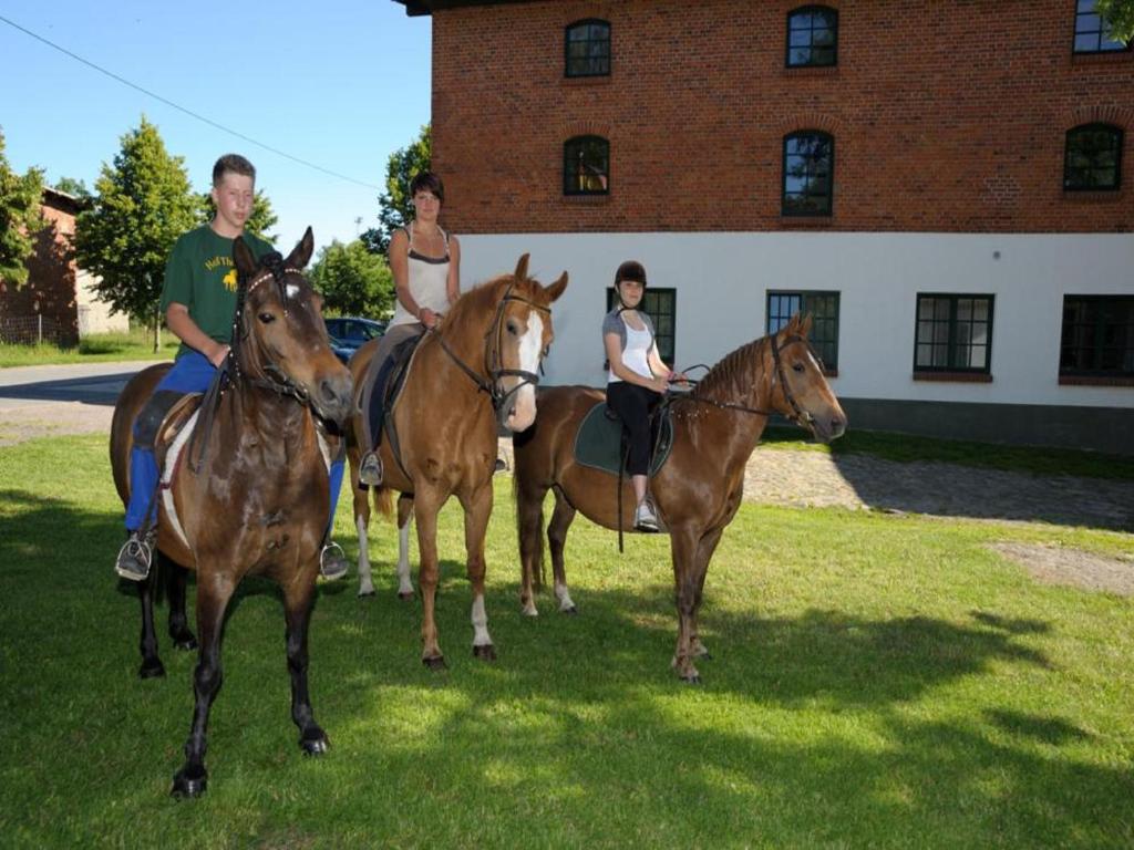 a group of people riding horses in front of a building at Hof Thomsen in Groß Kordshagen