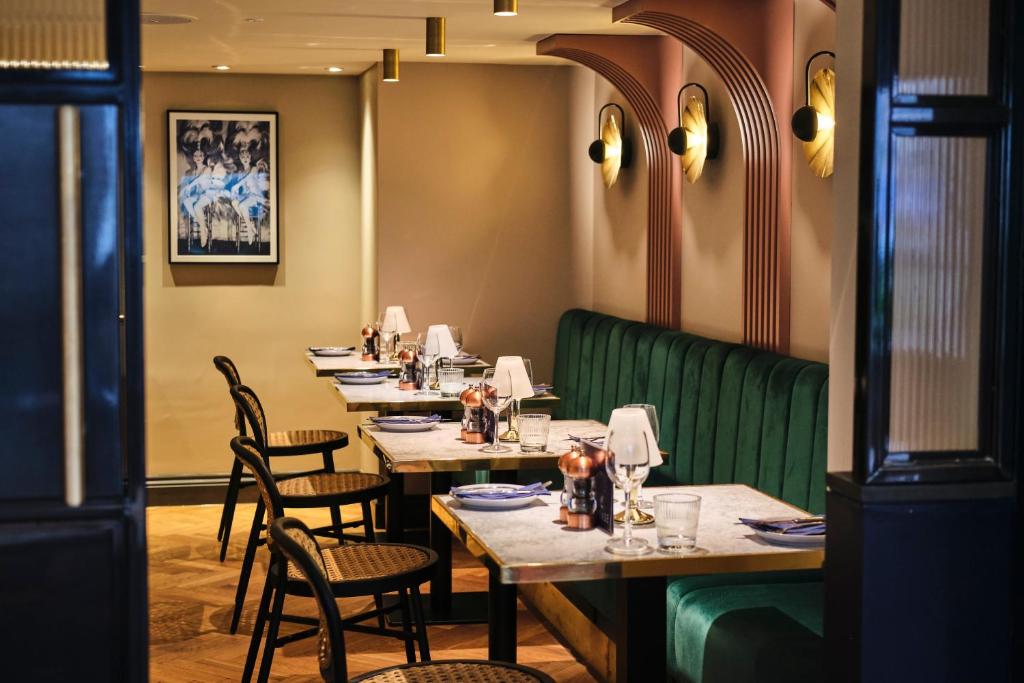 a row of tables in a restaurant with green booths at Le Monde Hotel in Edinburgh