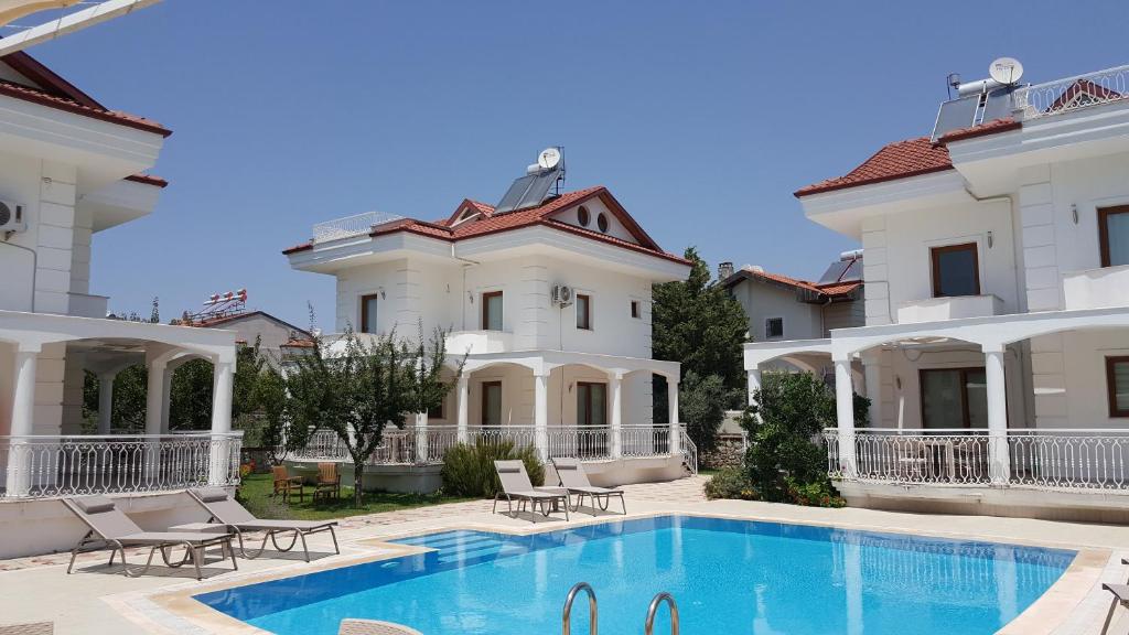 a large house with a swimming pool in front of it at Villa Ekin in Fethiye