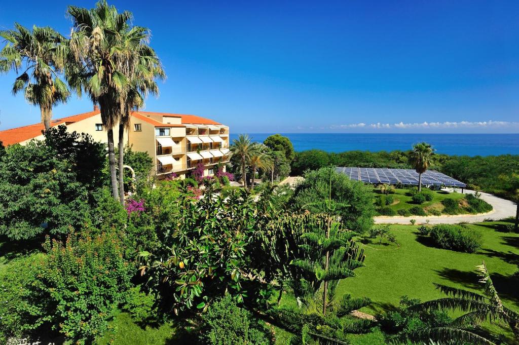 a view of a resort with palm trees and the ocean at Alberi Del Paradiso in Cefalù