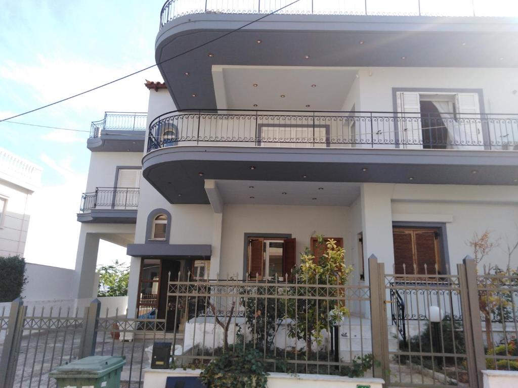 a white house with a balcony on top of it at Dora's Apartment 5 min from airport in Spata