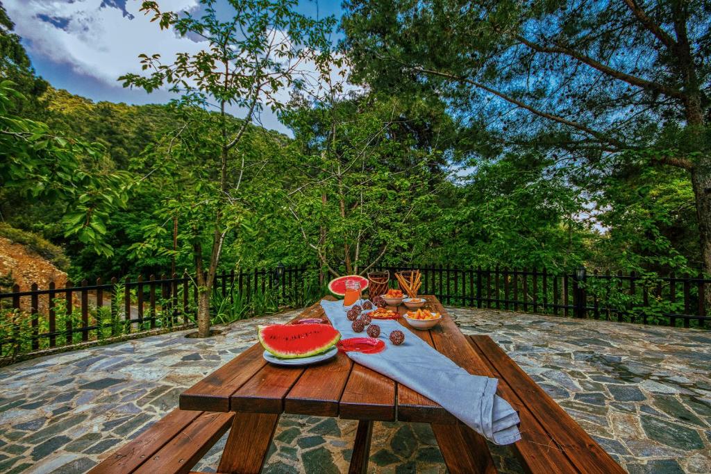 a wooden picnic table with a slice of watermelon on it at Persephone Cottage by AgroHolidays in Platres