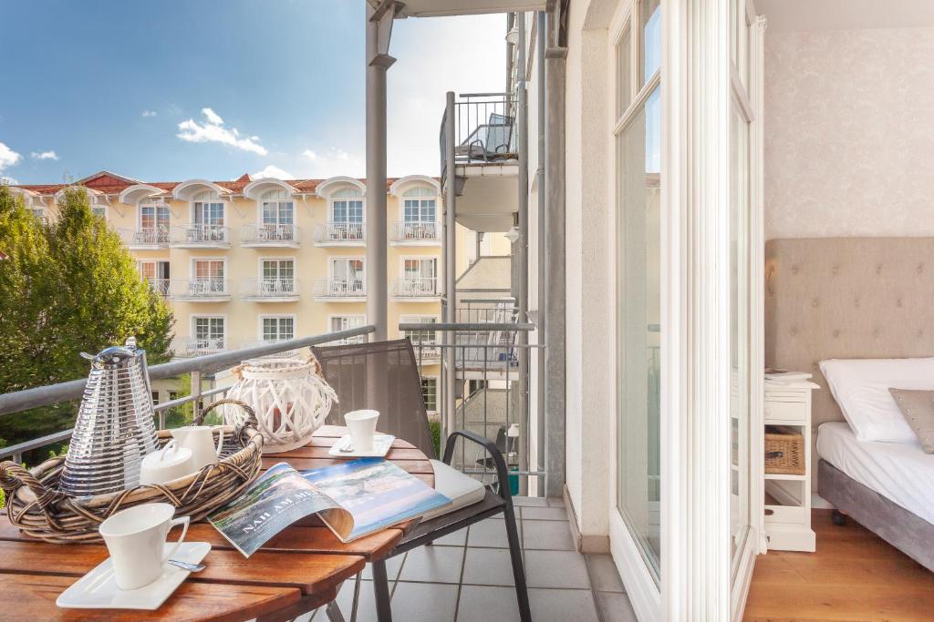 einen Balkon mit einem Tisch mit Büchern und einem Bett in der Unterkunft Appartement - Kleine Auszeit in Binz