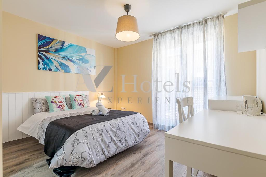 1 dormitorio con cama y mesa blanca en AYZ Villegas - Auto check-in property, en Madrid