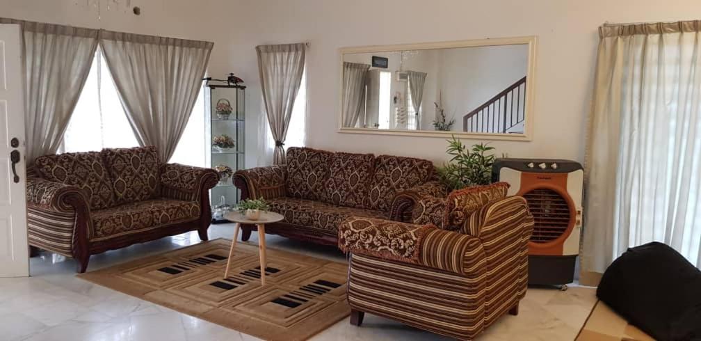 a living room with a couch and chairs and a mirror at Tun Perak Homestay in Rawang