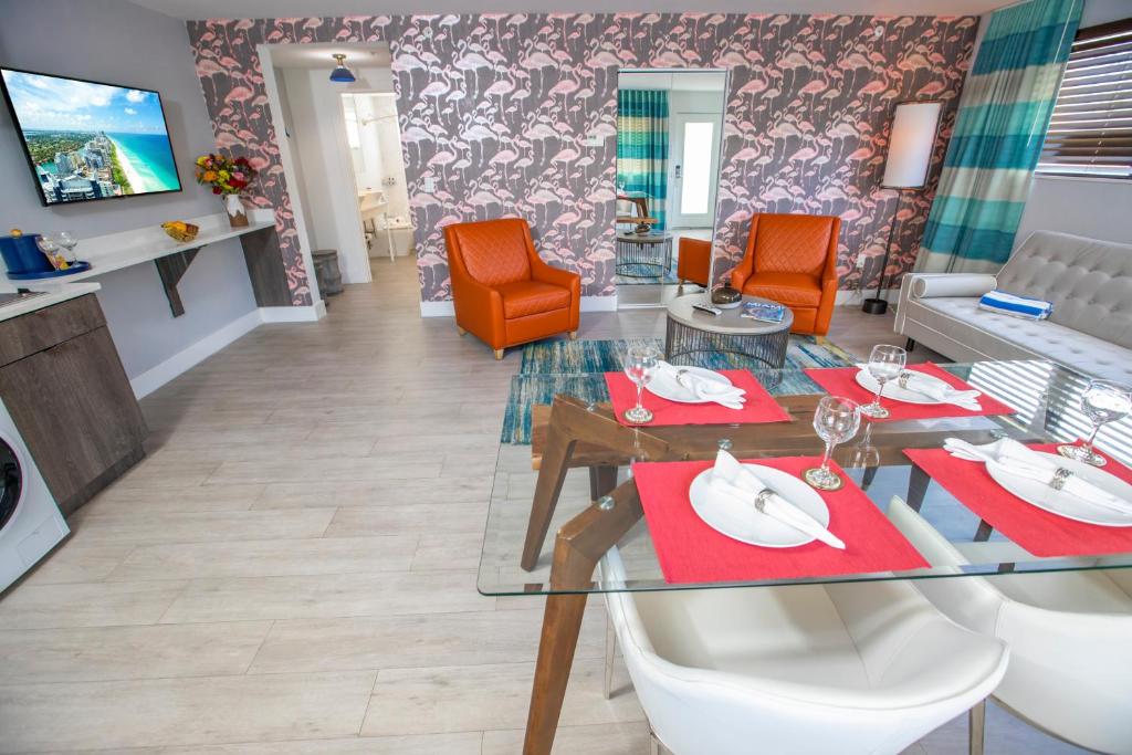 een eetkamer met een glazen tafel en oranje stoelen bij Waterside Hotel and Suites in Miami Beach