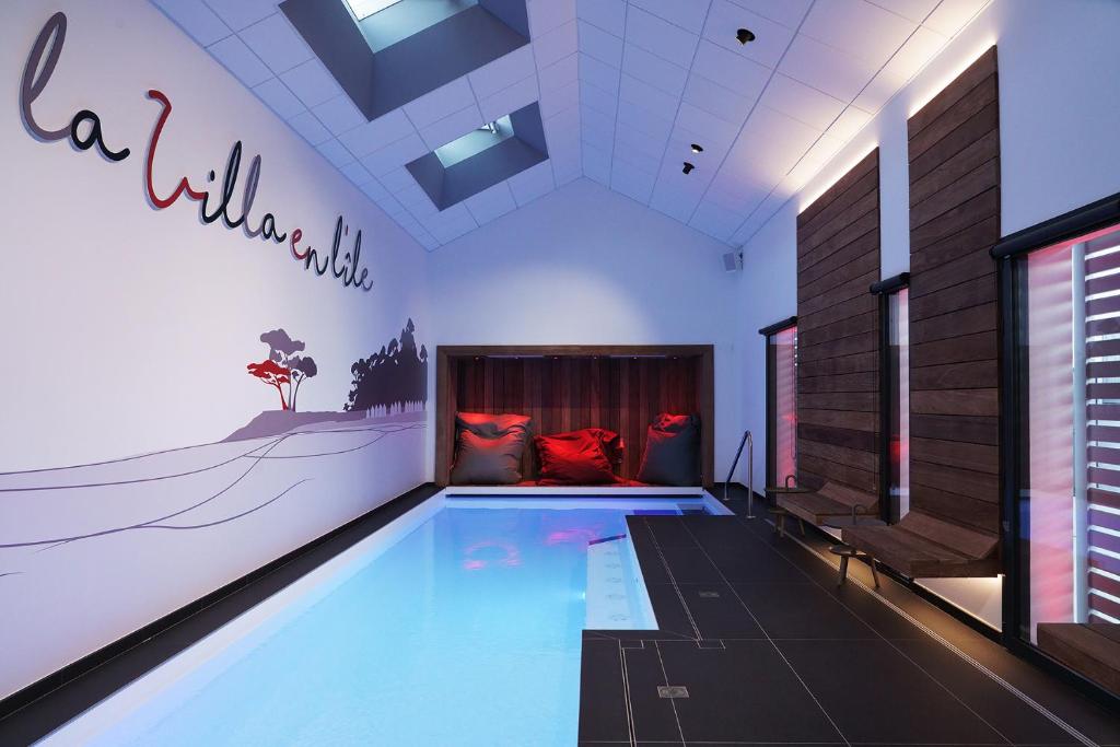 uma grande piscina numa sala com um quarto em La Villa en L'île - 2 Piscines & Spa em Noirmoutier-en-l'lle