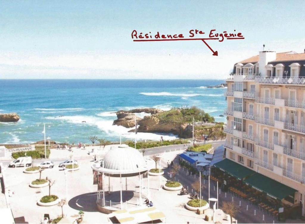 Blick auf den Strand, ein Gebäude und das Meer in der Unterkunft Petit appartement douillet très bien situé in Biarritz