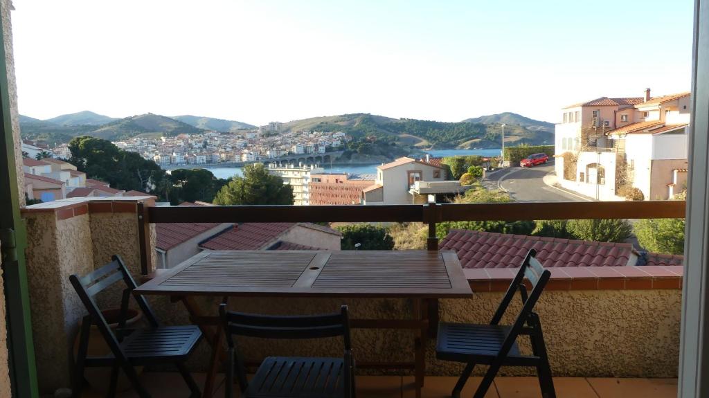 une table et des chaises sur un balcon avec vue dans l'établissement Maison T3 à Banyuls sur mer avec vue mer/montagne, à Banyuls-sur-Mer