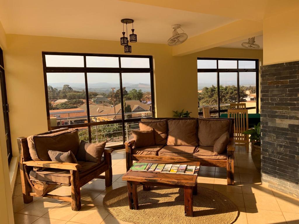 Sala de estar con 2 sofás y mesa en Lilac Elevate Inn, en Karatu
