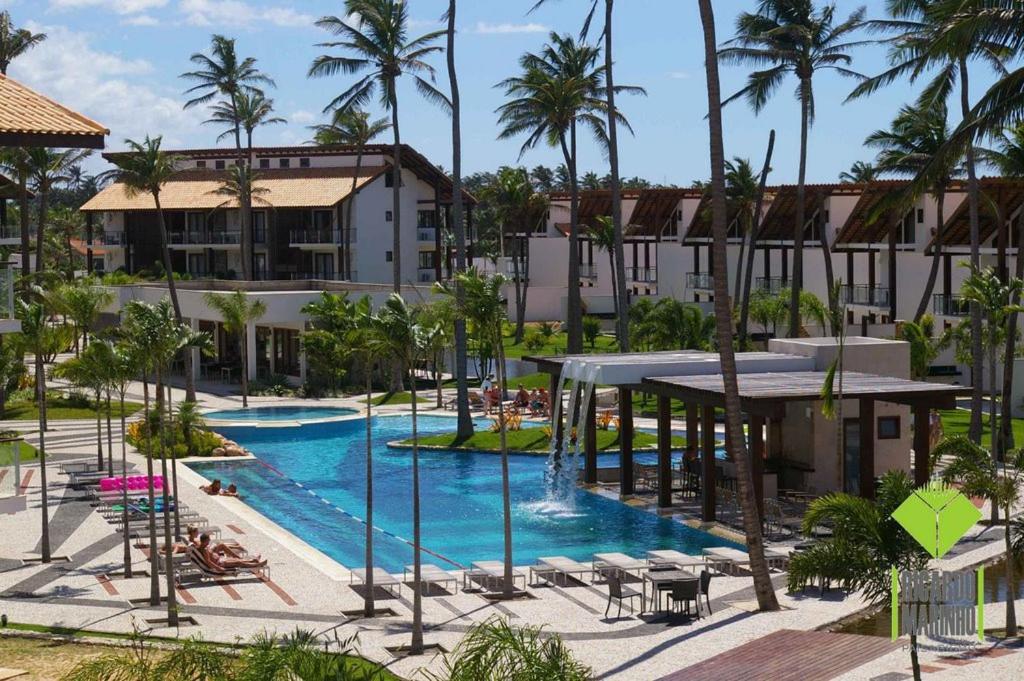 eine Luftaufnahme eines Resort-Pools mit Palmen in der Unterkunft Taiba Beach Resort Casa com piscina in Taíba