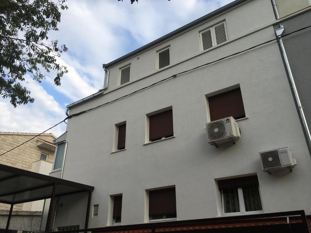 a white building with windows and air conditioners on it at Apartmani Mare in Split