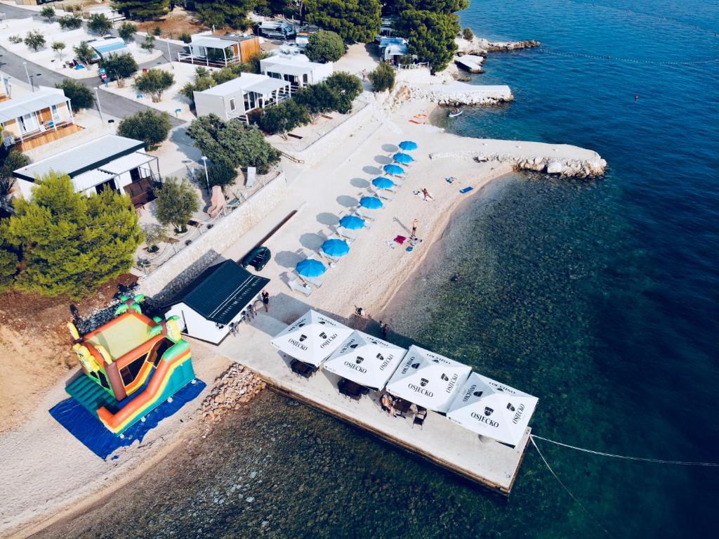 an aerial view of a beach with a pool and umbrellas at Camp Milo Moje in Drvenik