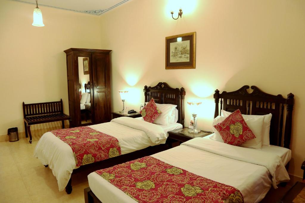a hotel room with two beds and two tables at Suryaa Villa - A Boutique Heritage Hotel in Jaipur